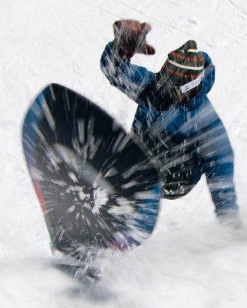 Jones Mountain Twin snowboard in azione durante una curva in powder su neve fresca